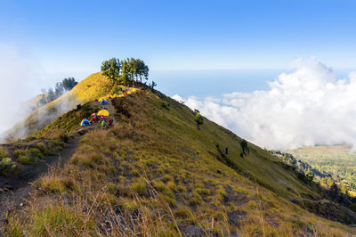 Men camping on mountain against sky