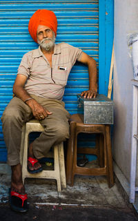 Portrait of man in turban sitting on stool