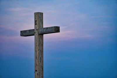 Low angle view of cross against sky