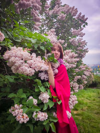 Young woman standing by flowering plants