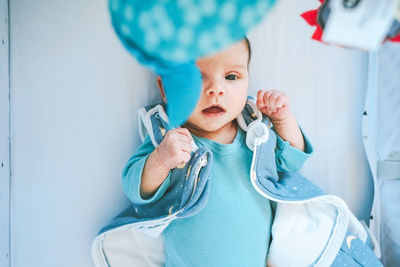 High angle view of baby lying on crib