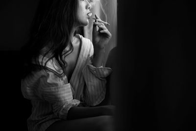 Young woman smoking at home