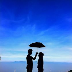 People standing by sea against sky