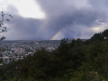 Scenic view of rainbow over city against sky