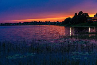 Scenic view of lake against sky at sunset