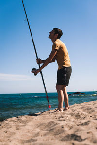 Full length of man fishing on beach