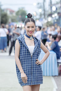 Portrait of smiling young woman standing in city