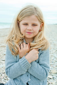 Portrait of young woman standing at beach