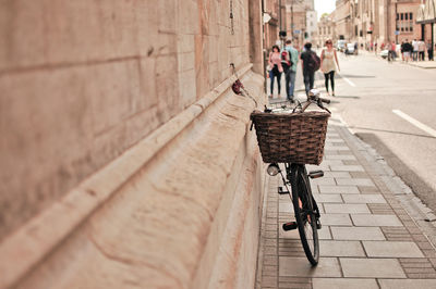 People in basket on street against wall in city