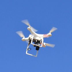 Low angle view of airplane flying against clear blue sky