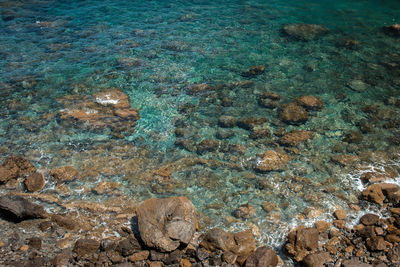 High angle view of rocks on sea shore