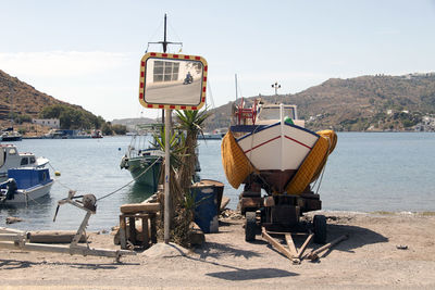 A view of a motorboat, and a motorbike passing by in the reflection  patmos, greece 