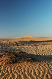 Scenic view of desert against clear blue sky