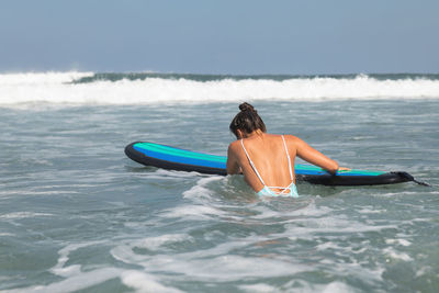 Rear view of woman swimming in sea