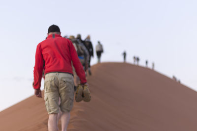 Rear view of man walking on beach