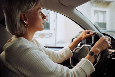 Inside view of a blond woman driving a car