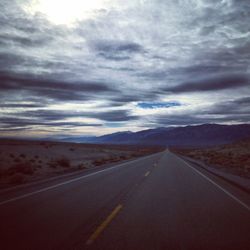 Country road against cloudy sky