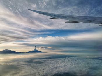 Aerial view of clouds over mountain against sky