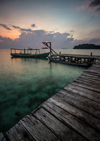 Pier over sea against sky during sunset