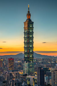 Illuminated buildings against sky during sunset