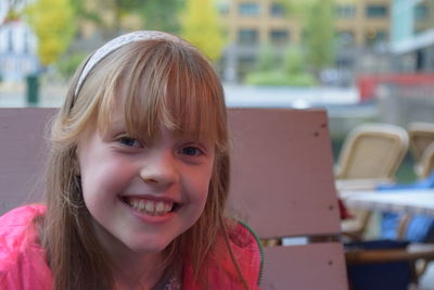 Portrait of smiling girl sitting outdoors