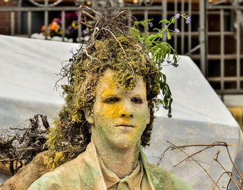 Man wearing costume with plants on head