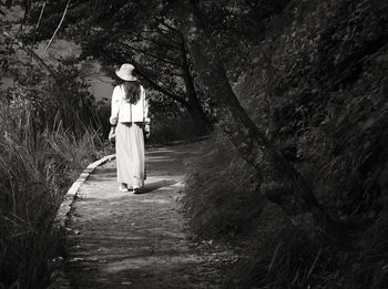 Woman standing by tree in forest