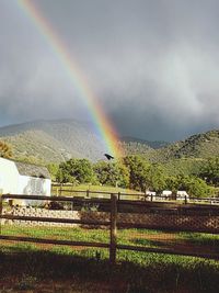 Scenic view of rainbow over landscape against sky