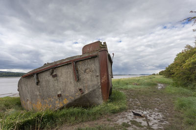 Abandoned building on field against sky