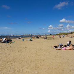 People at beach against sky