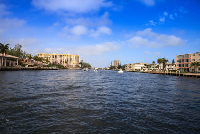 Buildings by sea against blue sky