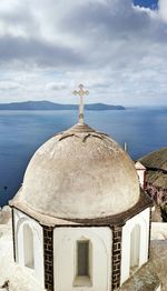 Traditional building by sea against sky