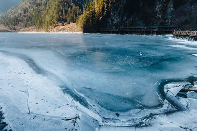 Scenic view of frozen lake against trees during winter