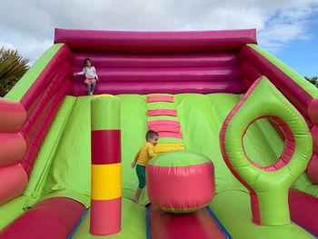 Siblings playing on bouncy castle