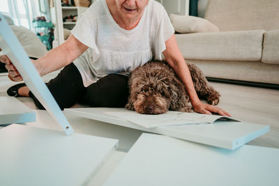 Woman with dog working on wood at home