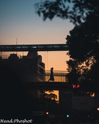 Silhouette bridge against sky at sunset