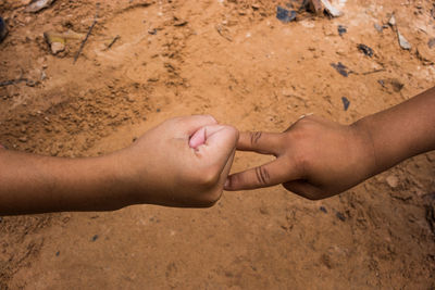 Close-up of baby hands on sand