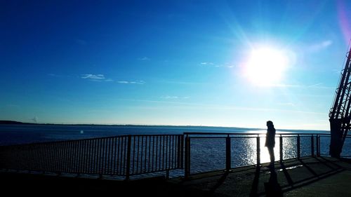 Scenic view of sea against blue sky on sunny day
