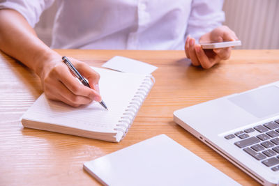 Midsection of man using laptop on table