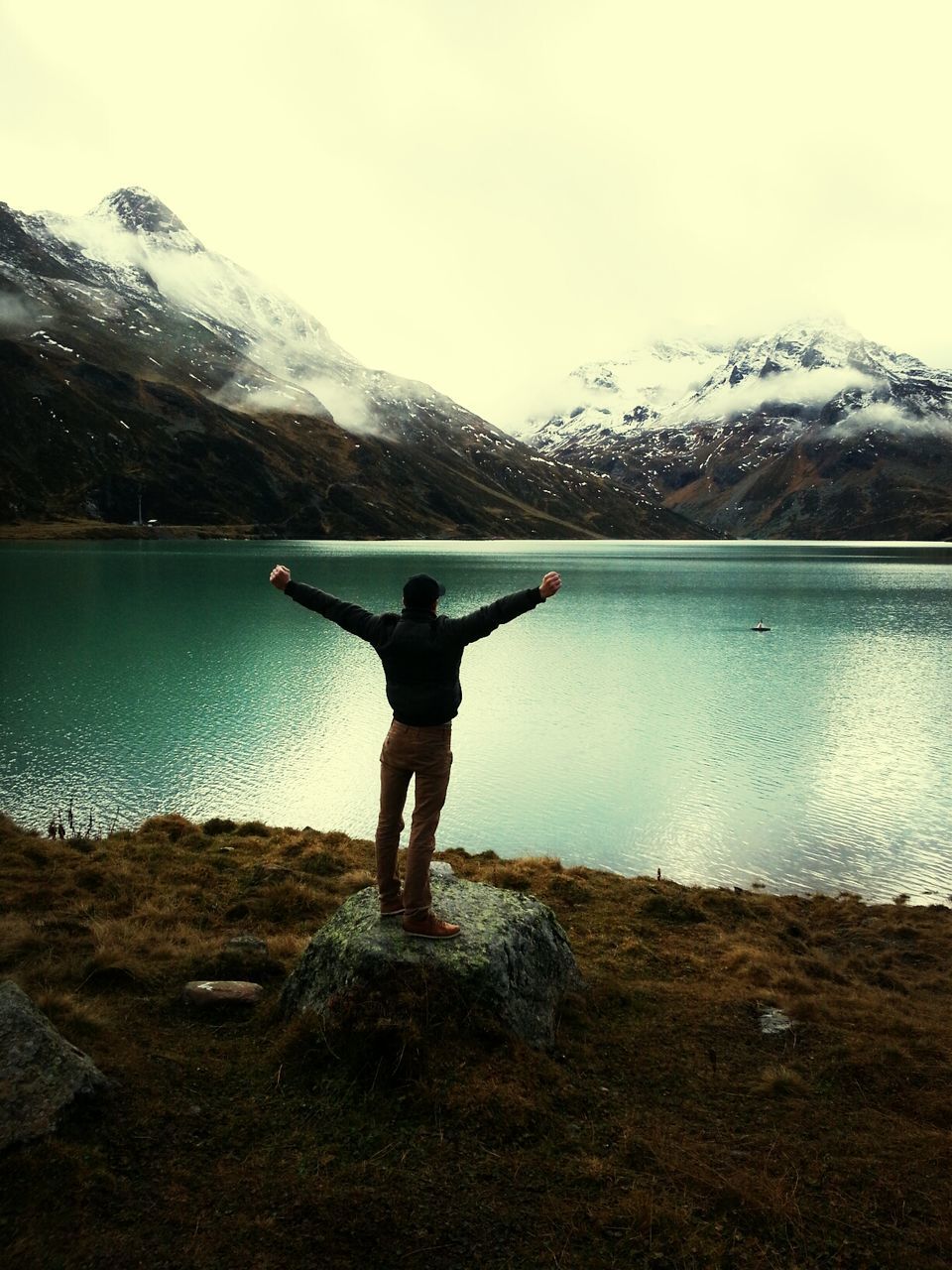 mountain, full length, rear view, leisure activity, water, lifestyles, standing, lake, tranquil scene, mountain range, tranquility, scenics, beauty in nature, winter, season, nature, snow, cold temperature