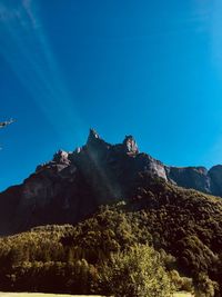 Low angle view of mountain against blue sky