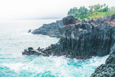 Scenic view of rocks in sea against sky