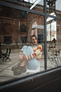Portrait of woman sitting by window