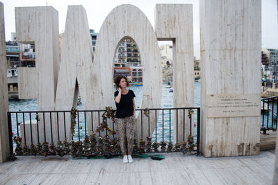 Full length of woman standing against buildings