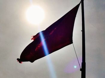 Low angle view of sun shining through clouds