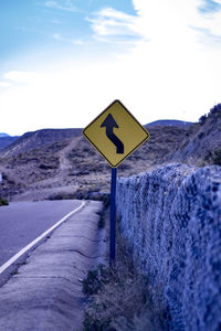 Road sign against sky