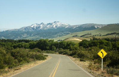 Road leading towards mountains against sky