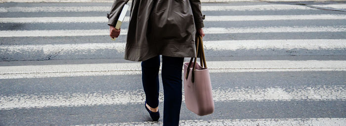 Low section of woman walking on zebra crossing