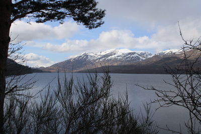 Scenic view of mountains and lake against cloudy sky