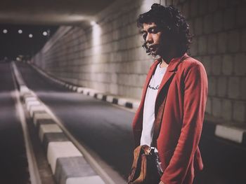 Side view of young man standing in subway